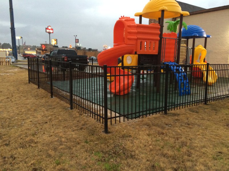 This vibrant playset was designed for a shopping centre playground in the Midwest United States. Featuring a nature-inspired tree theme, it includes a single orange curved slide, a yellow double straight slide, a blue arch climber, and several orange play panels. A cognitive number board adds an educational element for younger children. The structure is topped with green tree-themed accents, along with one yellow and one blue roof. Suitable for children ages 2 to 12, this photo highlights the orange curve slide.