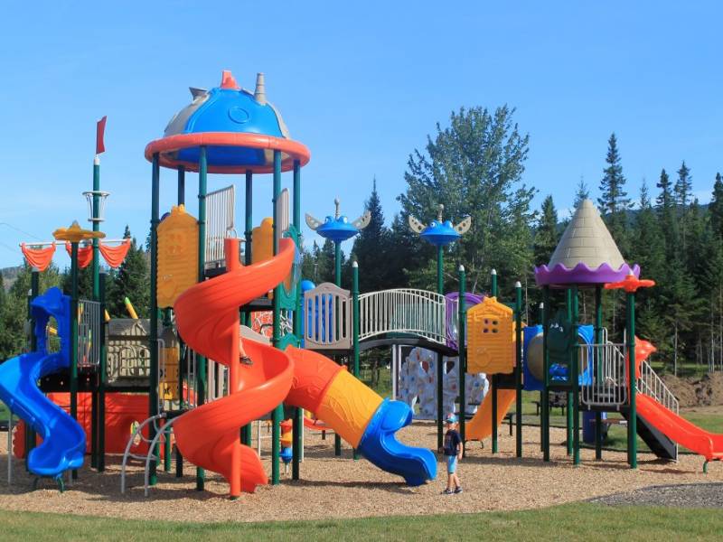 Large community outdoor playground in Shannon Quebec with space theme, tall spiral slides, climbing structures, and weather-resistant equipment.