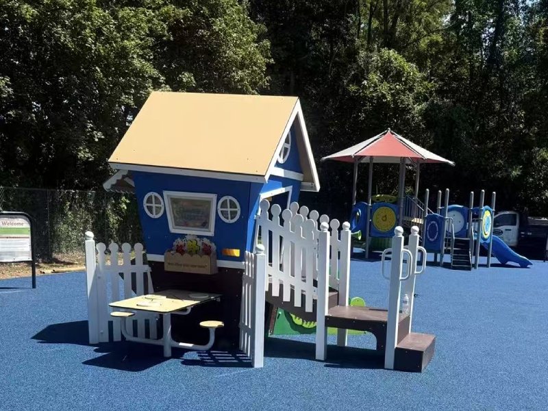 This KidsVenture Outdoor Playground features charming, cottage-style playhouses scaled specifically for infants, toddlers, and preschoolers. With bright blue panels, soft-toned roofs, and white picket-style railings, these structures create welcoming spaces that encourage imaginative play, social interaction, and early role-playing activities. Low-rise steps, wide platforms, and protective handrails support confident movement as young children develop balance and coordination. Children can safely enjoy gentle, toddler-friendly slides with smooth transitions and shallow slopes, providing age-appropriate excitement while strengthening gross motor skills. The multi-play structure includes interactive activity panels, peek-through windows, and crawl-through elements that stimulate curiosity, sensory engagement, and problem-solving. A shaded canopy adds comfort and visual interest while protecting children from direct sunlight and extending outdoor playtime.