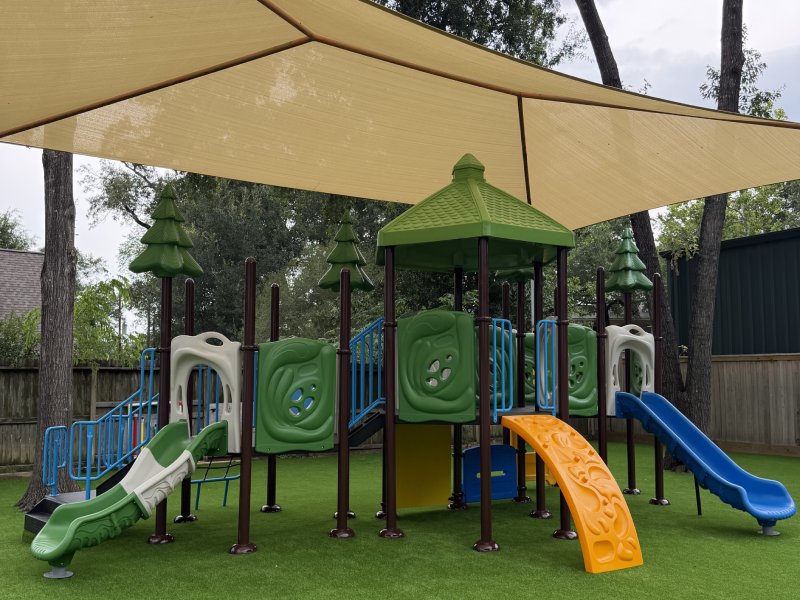 A natural tree themed outdoor play structure designed for 2 to 5 years old. Comes with many green interactive play boards, one twist slide and one blue straight slide, a bright yellow arch climber.